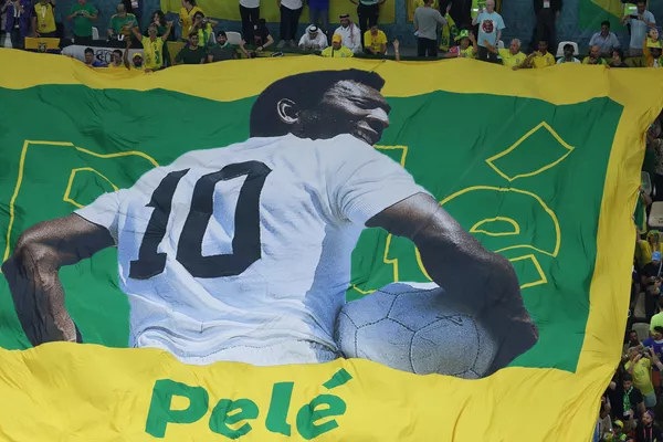 Una enorme bandera con la imagen de Pelé desplegada por los aficionados en las gradas antes del partido de la fase de grupos de la Copa Mundial 2022 entre Brasil y Camerún en Сatar. - Sputnik Mundo