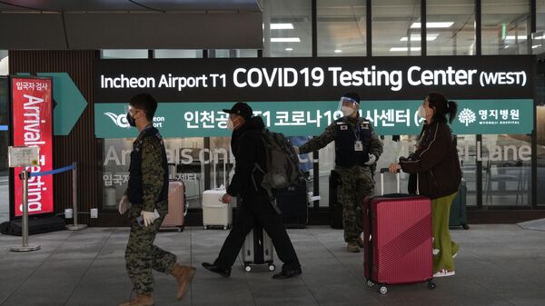 Pasajeros procedentes de China pasan por delante de un centro de pruebas COVID-19 en el Aeropuerto Internacional de Incheon, Corea del Sur. - Sputnik Mundo