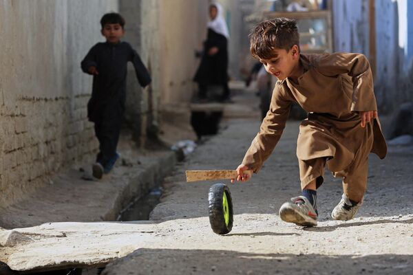 Un niño juega con una rueda en una calle de Jalalabad, Afganistán. - Sputnik Mundo