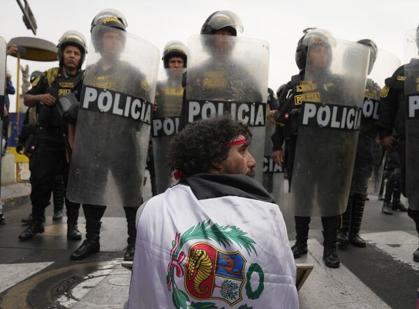 Un participante de las protestas antigubernamentales frente a un grupo de policías en la capital peruana de Lima. - Sputnik Mundo