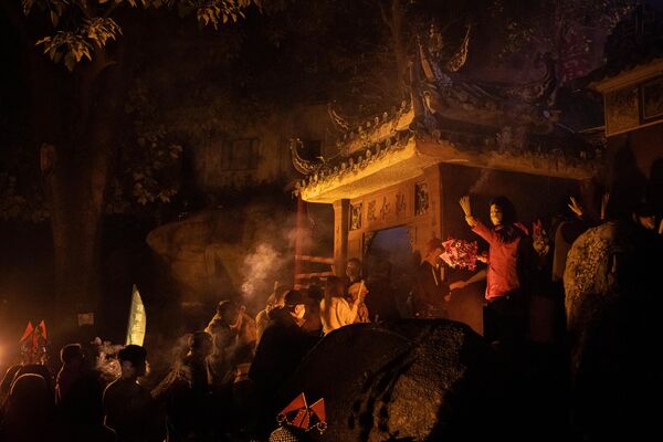 Varias personas sostienen varitas de incienso mientras pasean por el templo A-Ma durante el inicio de las celebraciones por el Año Nuevo Lunar chino en Macao. - Sputnik Mundo