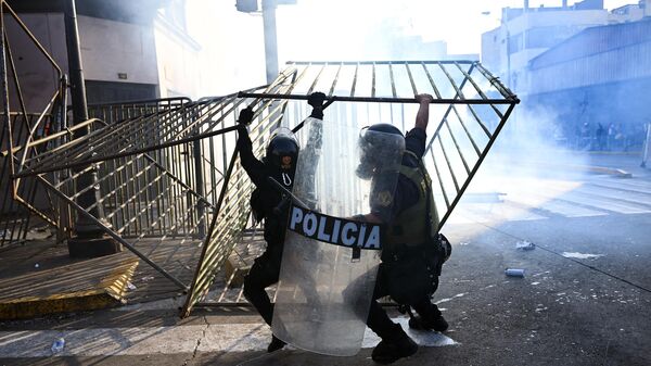 Policía antidisturbios de Perú remueve barricadas de protección durante una protesta en las inmediaciones del Congreso. - Sputnik Mundo
