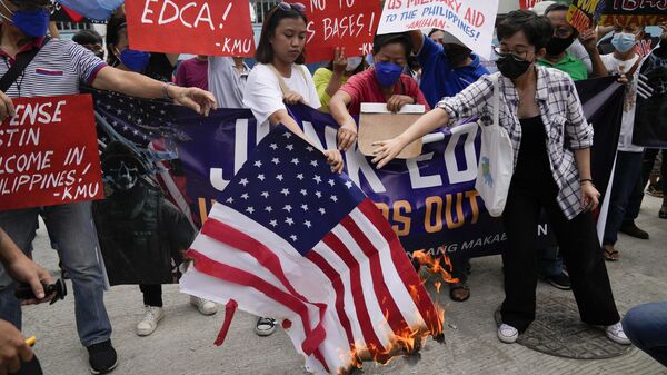 Manifestantes filipinos queman una bandera estadounidense en protesta por pacto militar con EEUU - Sputnik Mundo