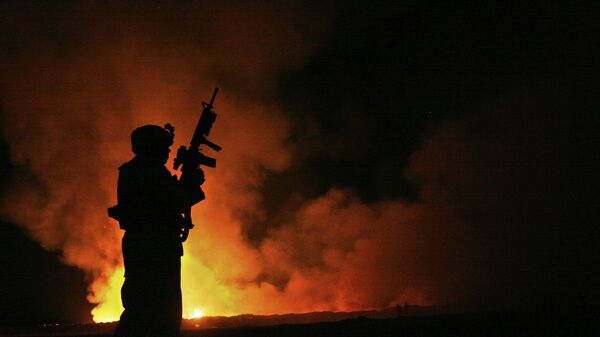 EL sargento Robert B Brown vigila a los bomberos civiles en el lugar del incendio mientras el humo y las llamas se elevan hacia el cielo nocturno a sus espaldasa, 25 de mayo de 2007  - Sputnik Mundo