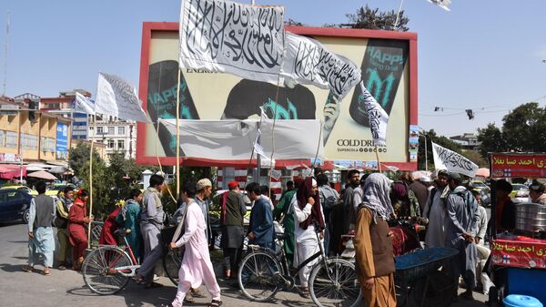 Personas portando banderas de los talibanes (Bajo sanciones de la ONU por actividad terrorista) en Mazar-i-Sharif. - Sputnik Mundo