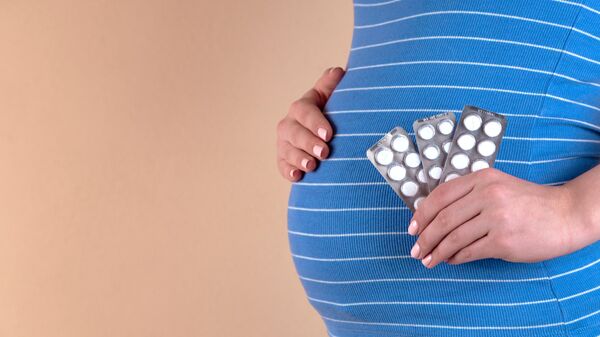 Una mujer embarazada con pastillas (imagen referencial) - Sputnik Mundo