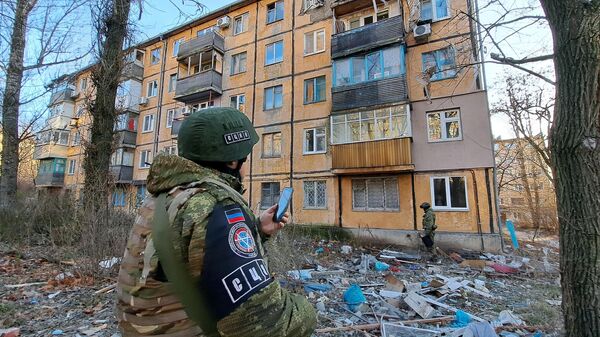 Personal del Centro de Control y Coordinación del Alto el Fuego y la Estabilización de la Frontera cerca de un edificio residencial dañado por los bombardeos de las Fuerzas Armadas Ucranianas en Donetsk. - Sputnik Mundo