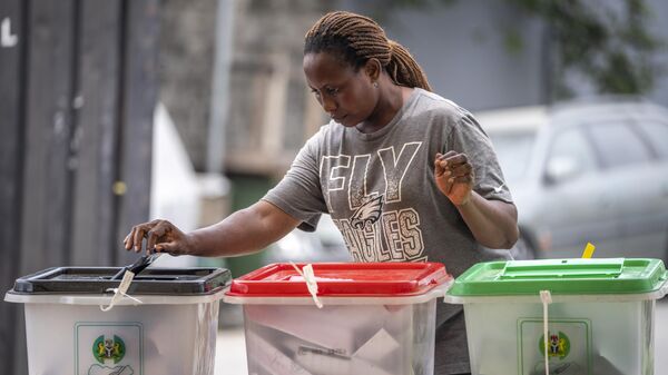 Una mujer deposita su voto durante las elecciones en Nigeria - Sputnik Mundo