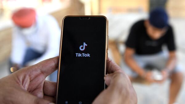 Usuarios de móviles navegan por la aplicación china de intercambio de vídeos TikTok en un smartphone  - Sputnik Mundo