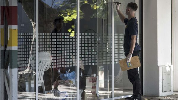 Un agente de policía inspecciona los agujeros de bala en una ventana de un supermercado perteneciente a la familia de Antonela Roccuzzo, la esposa de Lionel Messi, en Rosario, provincia de Santa Fe, Argentina, el 2 de marzo de 2023 - Sputnik Mundo