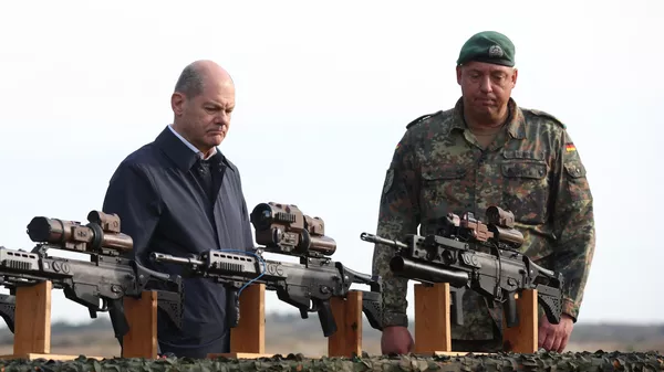 El canciller alemán Olaf Scholz observan los fusiles de asalto HK G36 de las fuerzas armadas alemanas Bundeswehr en Ostenholz, norte de Alemania, el 17 de octubre de 2022 - Sputnik Mundo