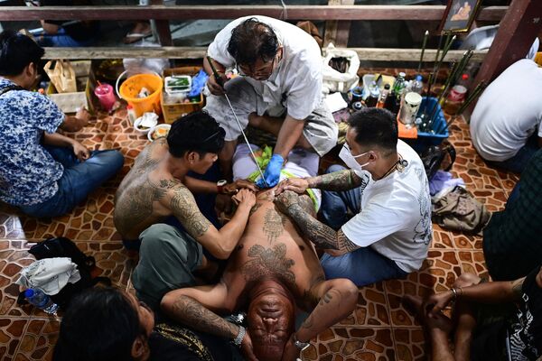 Un devoto budista se hace un tatuaje durante el festival anual de tatuajes sagrados en el templo de Wat Bang Phra, en la provincia tailandesa de Nakhon Pathom. - Sputnik Mundo