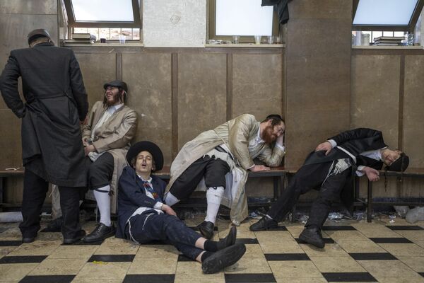 Judíos ultraortodoxos descansan tras celebrar la fiesta judía de Purim en una zona de Jerusalén, Israel. - Sputnik Mundo