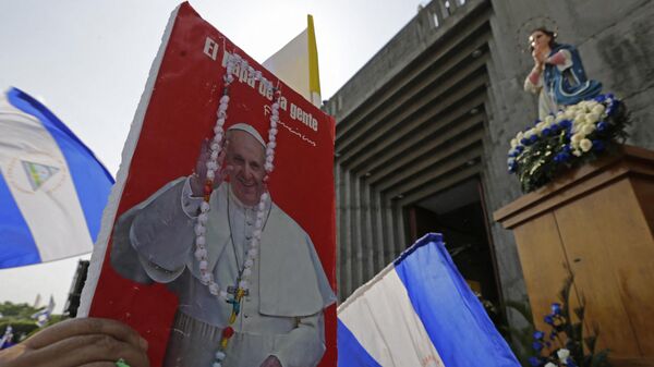 Un ciudadano nicaragüense sostiene una imagen del papa Francisco - Sputnik Mundo