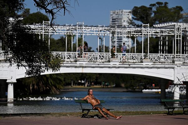 Un hombre toma sol en el parque Rosedal de Buenos Aires. - Sputnik Mundo