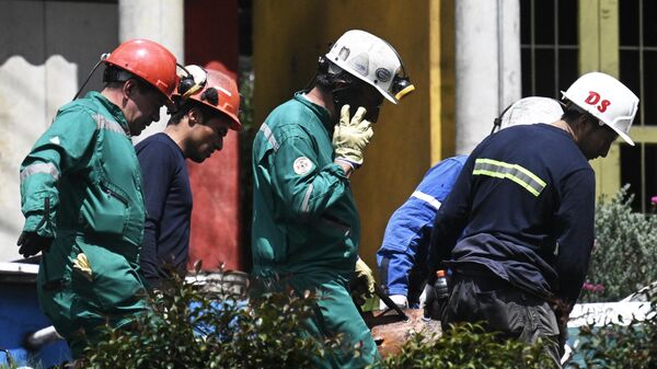 Bomberos cargan el cuerpo de un hombre que murió en la explosión de una de las minas del departamento colombiano de Cundinamarca. - Sputnik Mundo