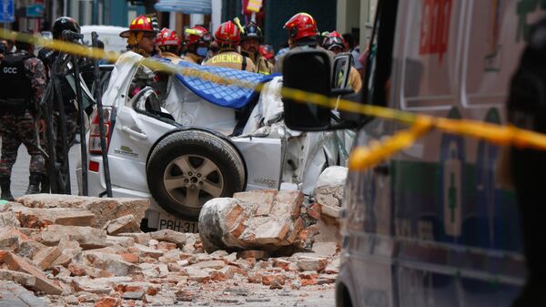Vista de un auto destruido tras la caída de una terraza de un edificio en el centro histórico de Cuenca, que dejó un muerto y una persona herida, tras un terremoto el 18 de marzo de 2023.  - Sputnik Mundo