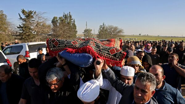 Personas llevan el cuerpo de Mohamed Elasibi, estudiante de medicina palestino de 26 años, durante su funeral en el pueblo beduino de Hura, en el sur de Israel, el 2 de abril de 2023. - Sputnik Mundo
