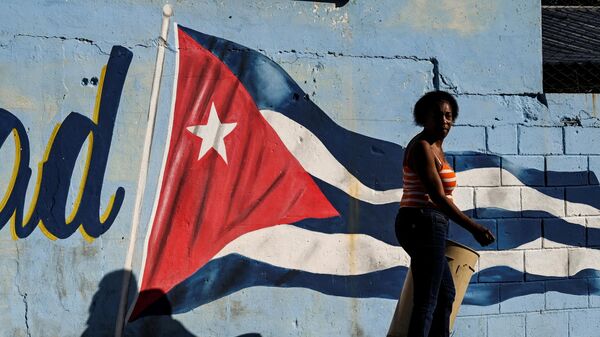 Una mujer pasa junto a un muro pintado con la bandera cubana con la leyenda Continuidad en La Habana, el 7 de febrero de 2023.  - Sputnik Mundo