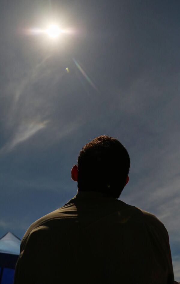 Se notó una corona solar durante el eclipse total.En la foto: la gente observa el fenómeno solar en la capital de Timor Oriental, Dili. - Sputnik Mundo