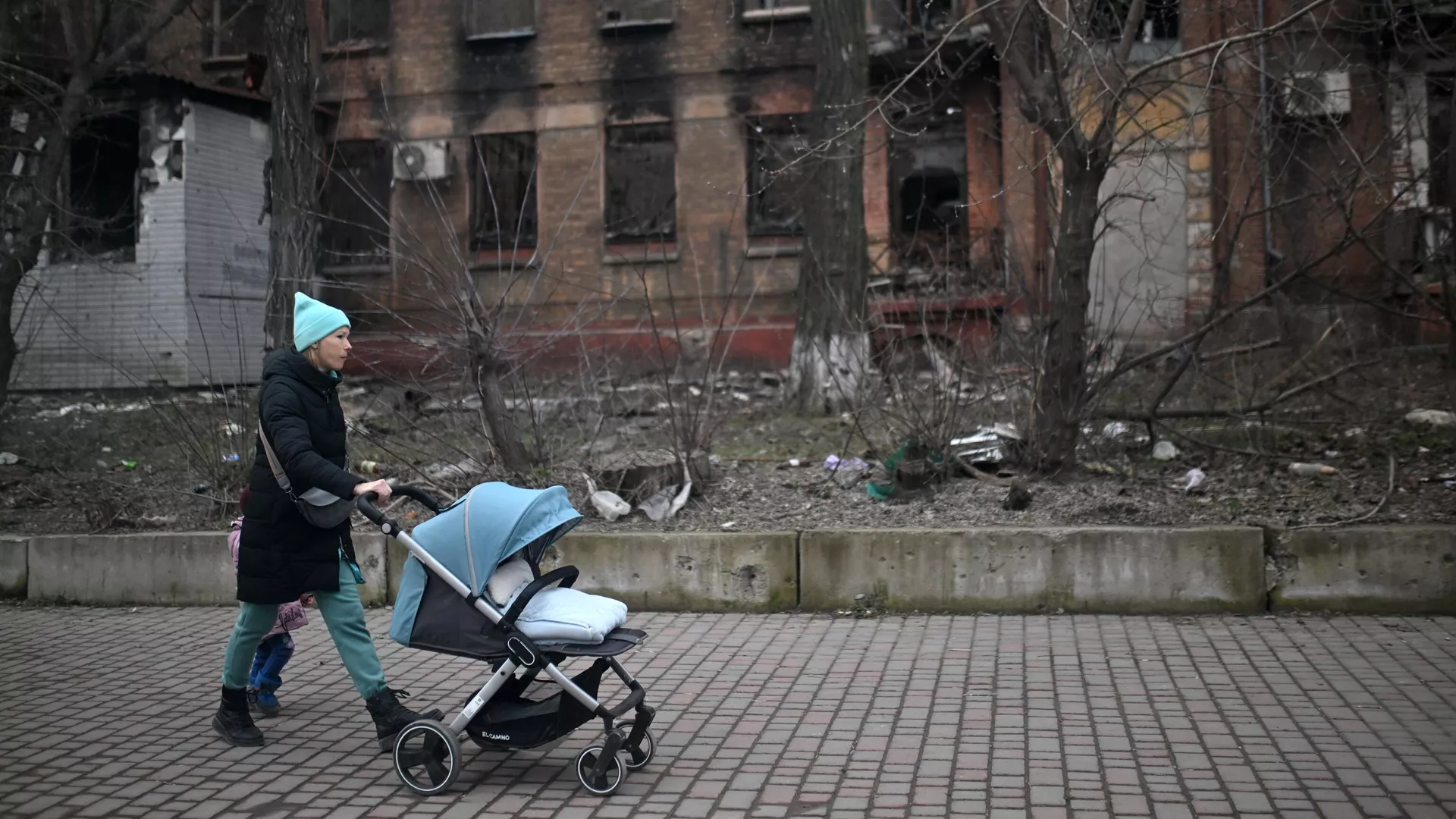 Una mujer con un cochecito de bebé en una calle de Mariúpol - Sputnik Mundo, 1920, 23.04.2023