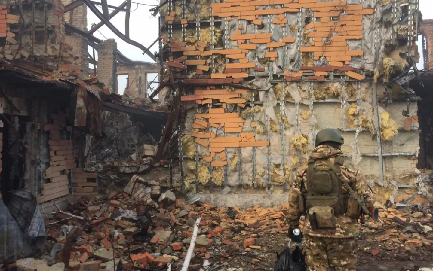 Soldato davanti a edifici distrutti - Sputnik World