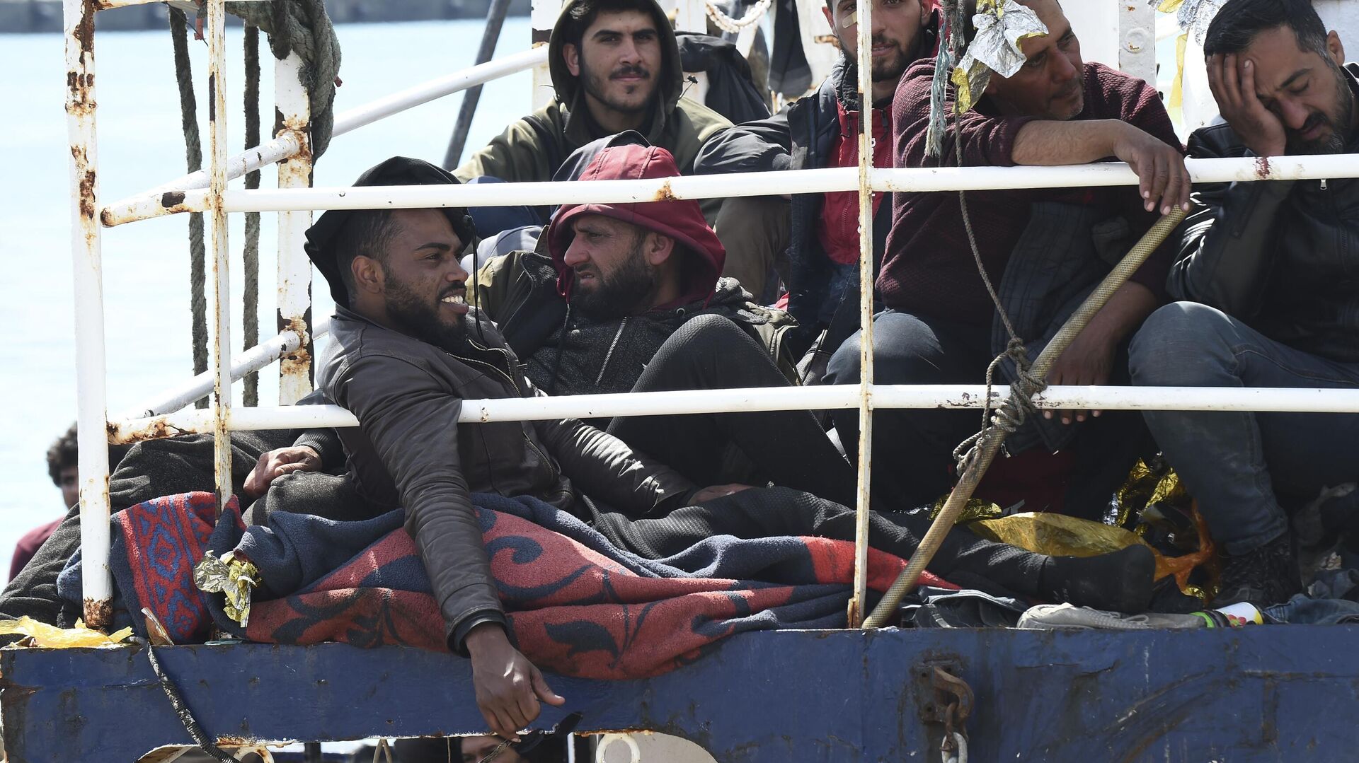 Migrantes esperan para desembarcar de un barco en el puerto siciliano de Catania, el 12 de abril de 2023 - Sputnik Mundo, 1920, 04.05.2023