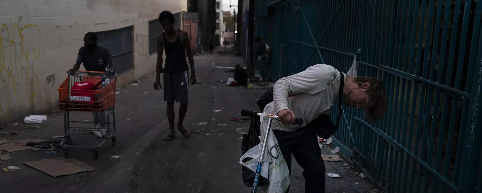 Un drogadicto sujeta el manillar de un patinete mientras se queda dormido tras fumar fentanilo en Los Ángeles, el martes 9 de agosto de 2022. - Sputnik Mundo, 1920, 25.11.2023