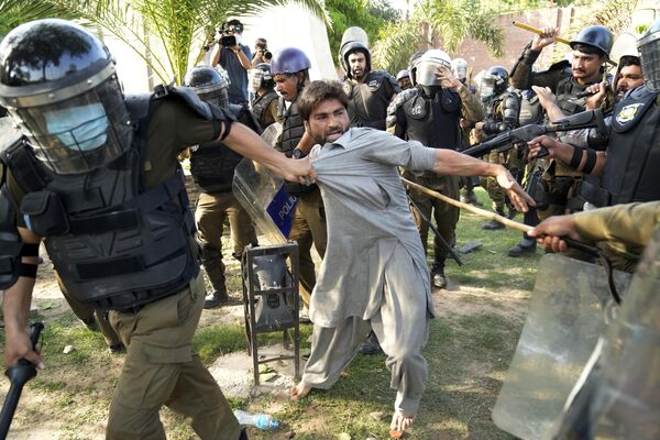 Policías detienen a un manifestante que protestaba contra la detención del ex primer ministro paquistaní Imran Jan en Lahore, Pakistán. - Sputnik Mundo