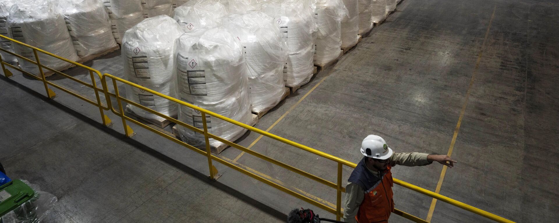 Un trabajador camina junto a sacos de litio listos para exportar en la planta procesadora de SQM en Antofagasta, Chile, el 19 de abril de 2023. - Sputnik Mundo, 1920, 06.07.2023