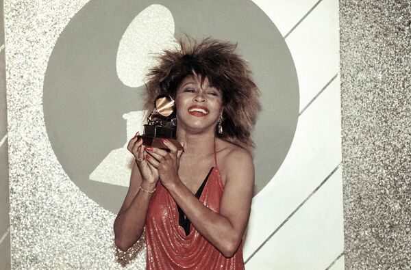 Anna May Bullock (nombre real de Tina Turner) nació el 26 de noviembre de 1939 en Nutbush, Tennessee, Estados Unidos, en el seno de una familia de clase trabajadora. Sus padres se divorciaron y pasó su infancia con su abuela. Tras la muerte de su abuela en los años 50, se trasladó con su madre a St. Louis, Missouri.En la foto: Tina Turner con la estatuilla de los Grammy, 1985. - Sputnik Mundo