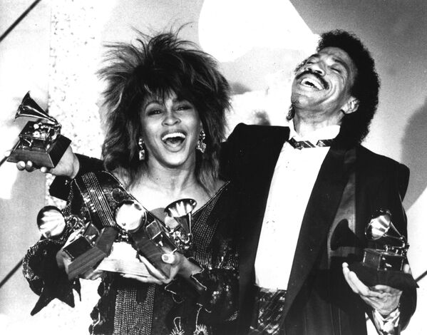 A los 17 años conoció a Ike Turner, fundador de The Kings of Rhythm, en un club nocturno de San Luis, que le pidió que se uniera a la banda como vocalista. Su relación pronto se volvió romántica, se casaron y en 1960 se formó el dúo Ike y Tina Turner. Ese mismo año se grabó la canción A Fool In Love, que vendió muchos millones de copias.En la foto: Tina Turner y Lionel Richie en los premios Grammy de 1985 en Los Ángeles. - Sputnik Mundo