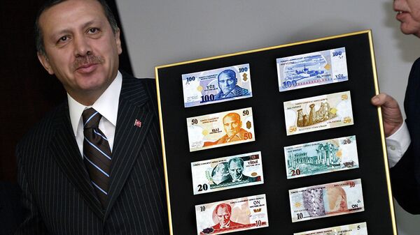Recep Tayyip Erdogan, presidente de Turquía, sostiene un tablero con las muestras de liras turcas - Sputnik Mundo