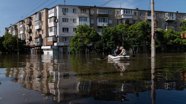 Residentes locales en un bote durante una evacuación de un área inundada en Jersón el 7 de junio de 2023 - Sputnik Mundo