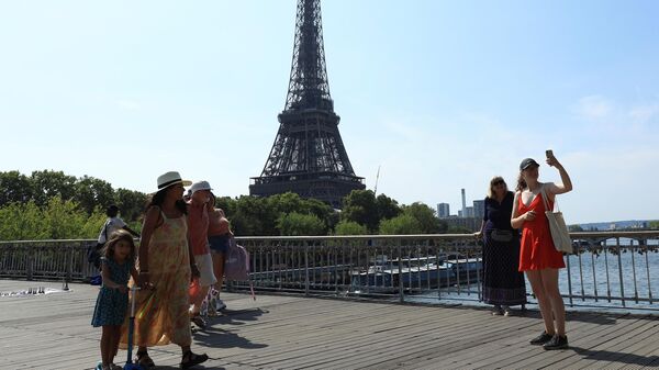 Turistas se hacen un selfie cerca de la Torre Eiffel en 2022 en París, Francia (Imagen referencial) - Sputnik Mundo