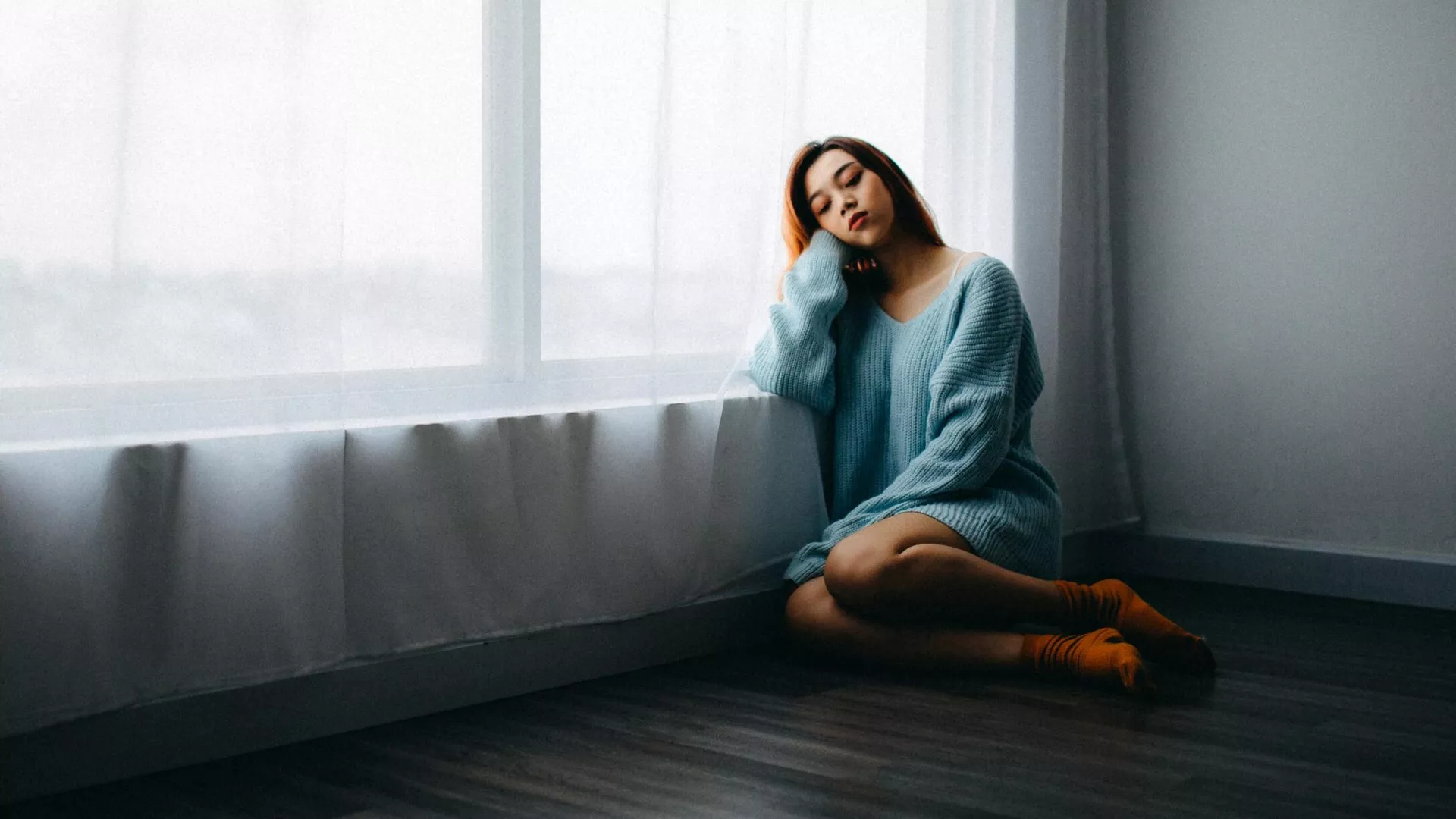 Una mujer sentada en el suelo cerca de una ventana (imagen referencial) - Sputnik Mundo, 1920, 21.06.2023