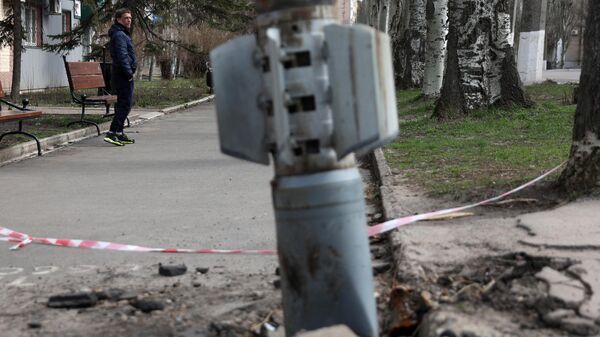 Un hombre camina cerca de un cohete de 300 mm que parece haber contenido bombas de racimo en Lisichansk, región de Lugansk, el 11 de abril de 2022. - Sputnik Mundo