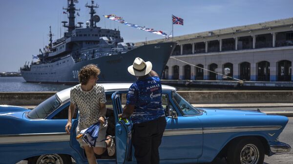 Туристка выходит из классического американского автомобиля перед учебным кораблем ВМФ России Перекоп в Гаванской бухте, Куба - Sputnik Mundo