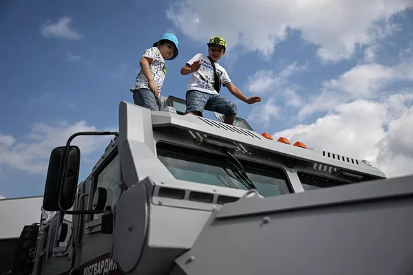 Niños en el techo del vehículo blindado polivalente Spartak. La parte frontal y los laterales del vehículo, incluidas las ventanillas, pueden resistir balas incendiarias perforantes, mientras que la parte inferior protege a la tripulación de la detonación de artefactos explosivos bajo las ruedas de hasta 6 kg de equivalente en TNT. - Sputnik Mundo