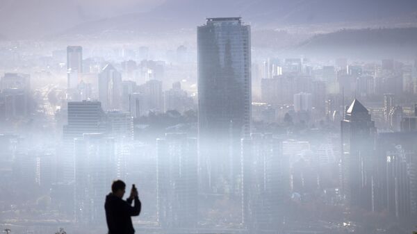 Человек фотографирует смог над Сантьяго - Sputnik Mundo