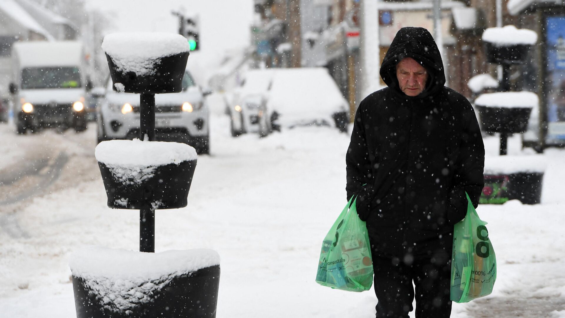 Un hombre lleva sus compras a través de la nieve en Escocia, el 18 de febrero de 2022  - Sputnik Mundo, 1920, 03.09.2023