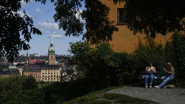 Mujeres disfrutan de una comida en un parque, con una Iglesia al fondo, en Estocolmo, Suecia - Sputnik Mundo