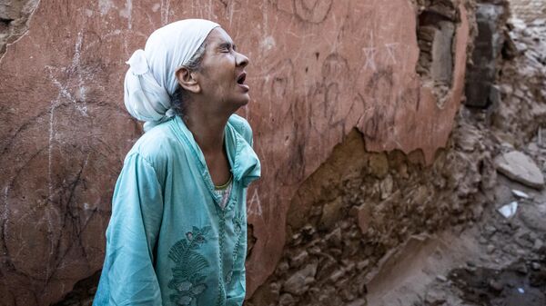 Женщина стоит перед своим поврежденным домом от землетрясения в старом городе Марракеша, Марокко - Sputnik Mundo