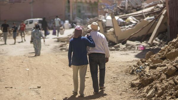 Personas caminan entre los escombros causados por el terremoto en la ciudad de Amizmiz, cerca de Marrakech, Marruecos, el 10 de septiembre de 2023 - Sputnik Mundo