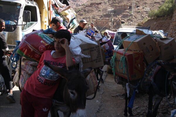 Adultos y niños participan en el reparto de ayuda en las montañas afectadas por el terremoto de Marruecos, 15 de septiembre de 2023 - Sputnik Mundo