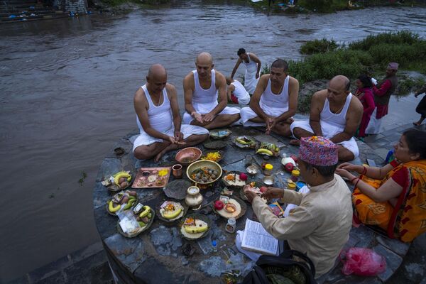 Devotos hindúes nepalíes celebran rituales por sus padres fallecidos a orillas del río Bagmati durante el festival Kuse Aunsi en el templo de Gokarneshwor, Katmandú. - Sputnik Mundo