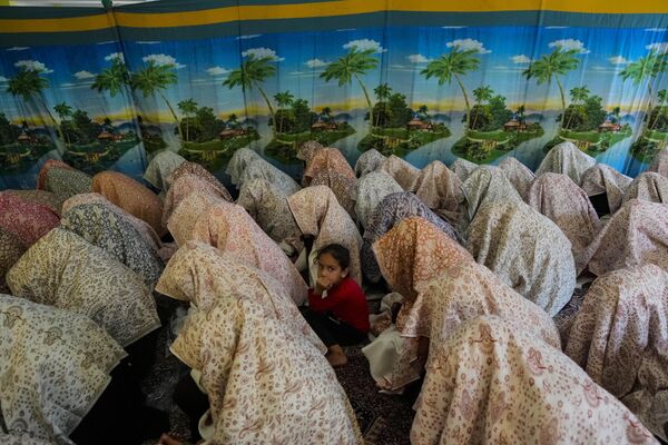Una niña sentada entre novias musulmanas durante una boda multitudinaria en la región de Cachemira, controlada por la India. Las bodas colectivas son organizadas para ayudar a las familias, que no pueden permitirse los elevados costos de la ceremonia. Una niña sentada entre novias musulmanas durante una boda multitudinaria en la región de Cachemira, controlada por la India. Las bodas colectivas son organizadas para ayudar a las familias, que no pueden permitirse los elevados costos de la ceremonia. - Sputnik Mundo