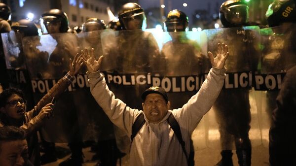 Manifestantes antigubernamentales se enfrentan a una fila de policías durante una marcha por el centro de Lima, Perú - Sputnik Mundo