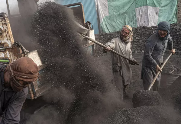Trabajadores afganos cargan de carbón un camión en un depósito carbonífero a las afueras de Kabul, Afganistán. - Sputnik Mundo