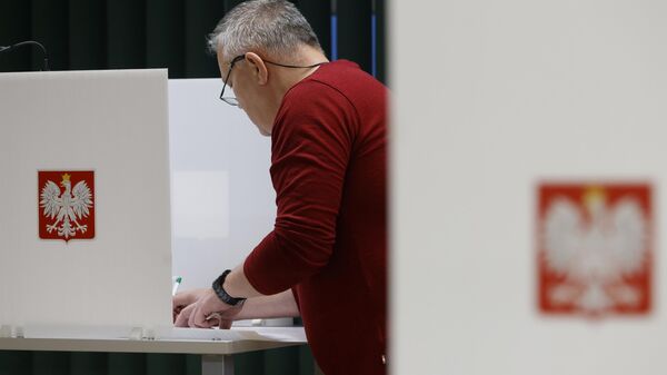 Una persona se prepara para depositar su voto durante las elecciones parlamentarias en Varsovia, Polonia, el 15 de octubre de 2023. - Sputnik Mundo